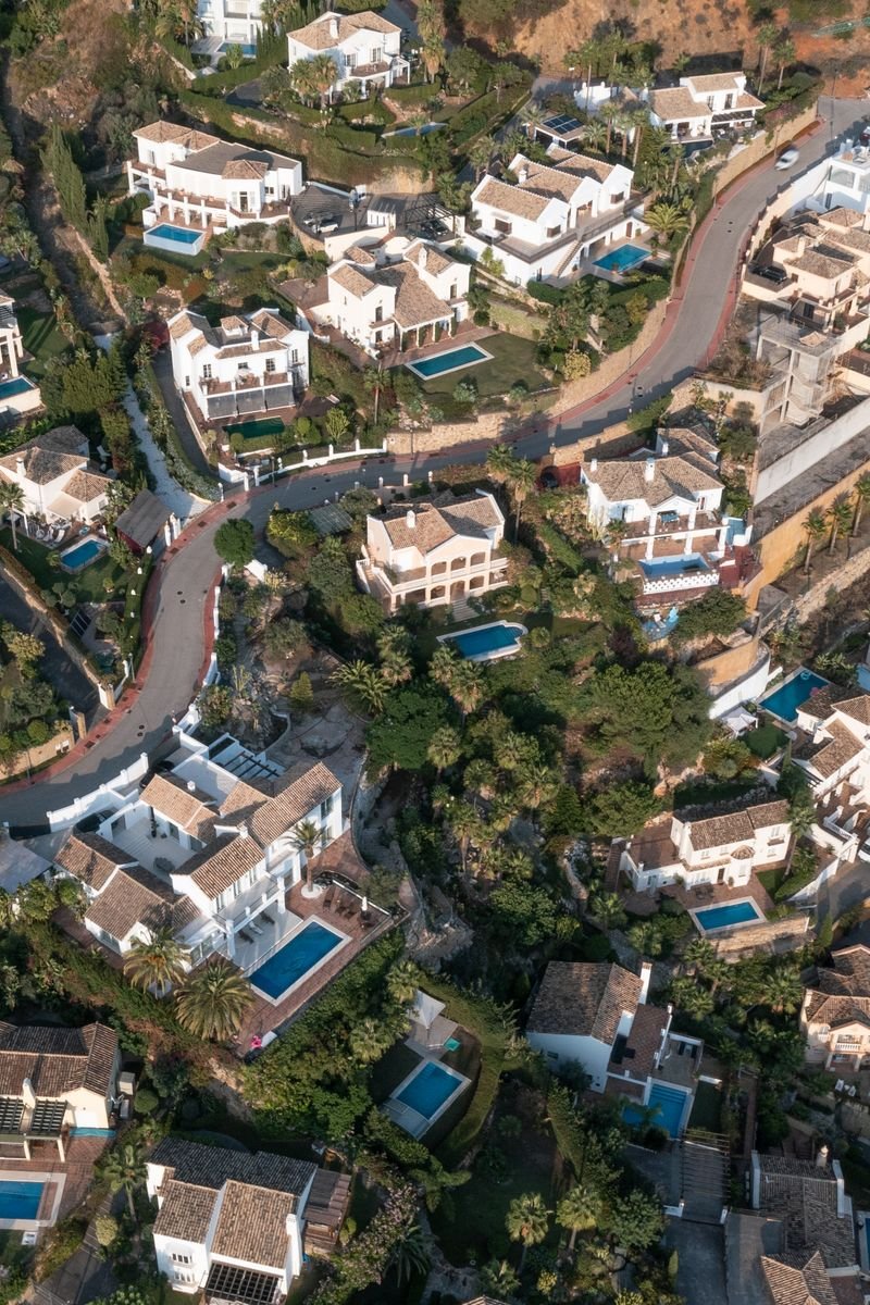 Aerial view showcasing a picturesque suburban area in Spain with elegant homes and pools.